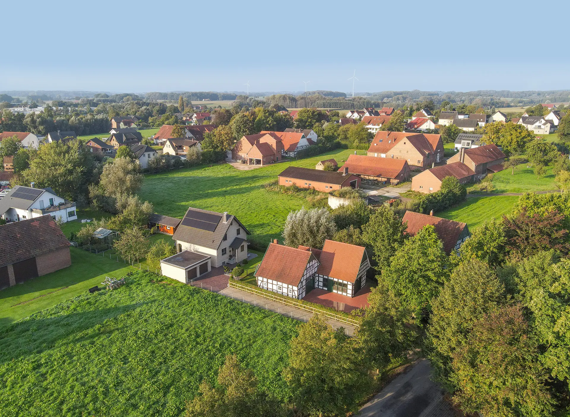 Luftaufnahme zeigt im Vordergrund das Heimathaus mit Backhaus und die Dorfansicht