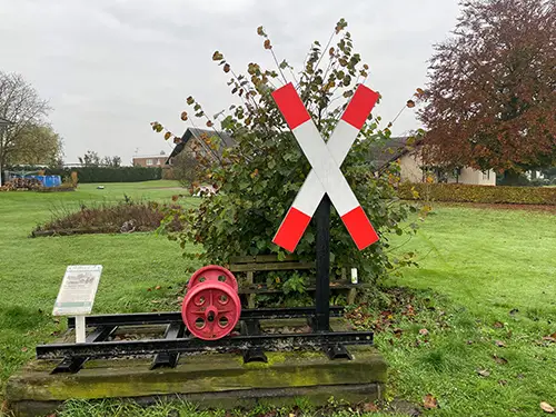 Ein Bahnkreuz, ein Schinenstück und Wagonräder als ERinnerung an den ALTEN BAHNDAMM